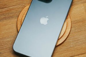 A modern smartphone placed on a wooden table, showcasing its sleek design.