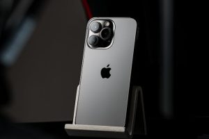 A modern smartphone displayed on a stand against a dark, minimalist background.