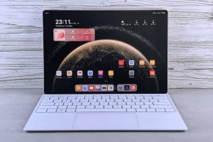 A sleek tablet with a keyboard showing a digital interface, against a wooden background.